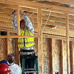 A student works on the electrical wiring of a new house.